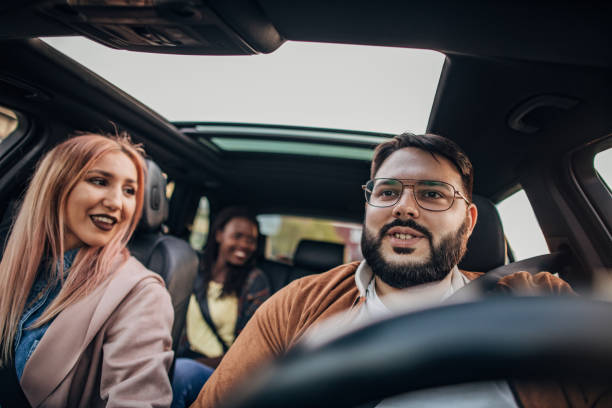 Group of friends on fun road trip Group of friends driving in the car and going on the road trip car city urban scene commuter stock pictures, royalty-free photos & images