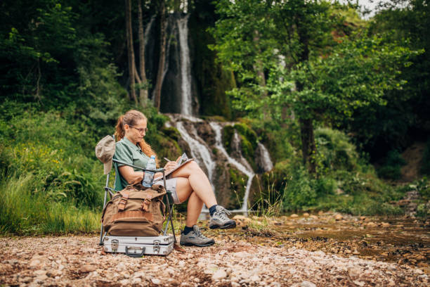 istock Woman biologist contemplating by the waterfall 1183128127