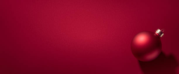 istock Christmas bauble on red seamless backdrop, luxury winter holiday card background 1183128275