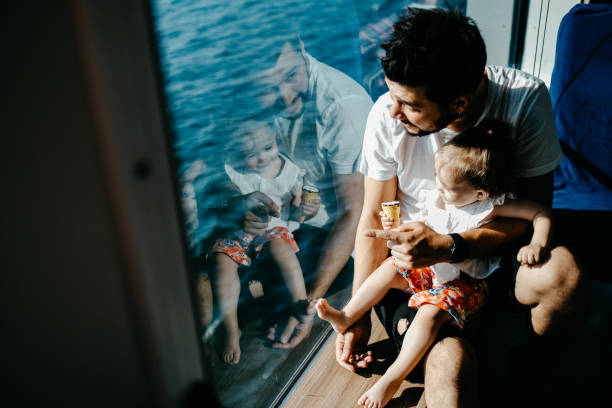 chica viajando en barco con su padre y mirando a través de la ventana - ferry fotografías e imágenes de stock