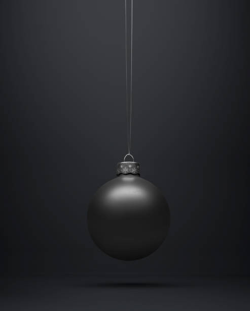 istock Matte black Christmas ball hanging centered on a black background. 1183129318