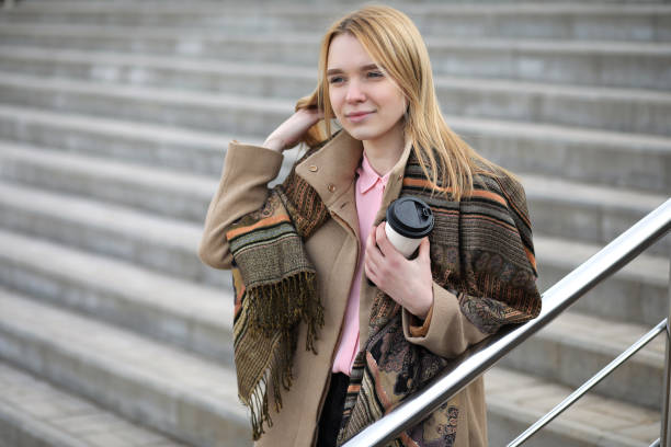 istock Cute blonde in the city drinking coffee 1183129381