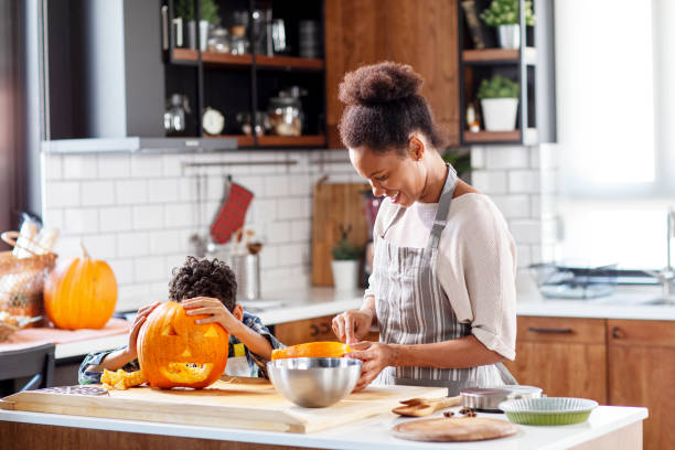istock Preparing for halloween mother with his son at the kitchen cut pumpkin 1183129835