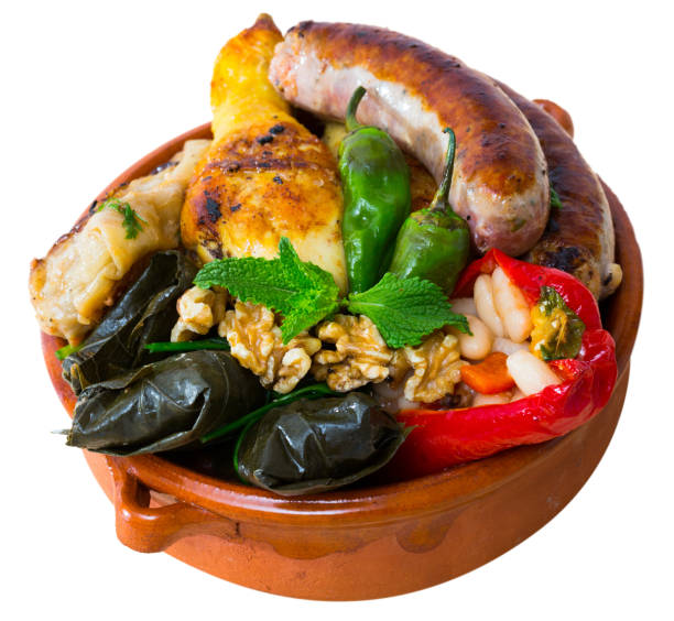 Bulgarian dish Kapama National festive Bulgarian dish Kapama - stew from several types of meat and sausages with stuffed vegetables served with greens and walnuts. Isolated over white background kapama reserve stock pictures, royalty-free photos & images