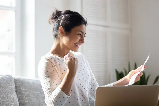 Photo of Happy Indian woman reading good news in letter, notification