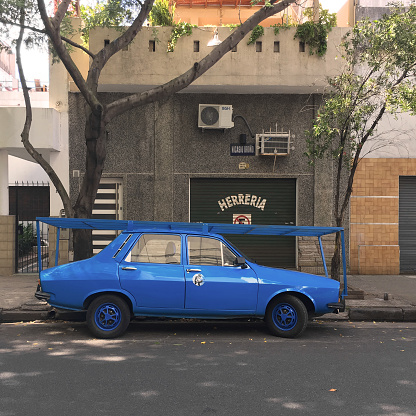 Buenos Aires, Argentina - April 6, 2019: A closed blacksmith shop with its business car parked in front of it. It has a specialized car with a wide rack on it to be able to transport the big iron stuff constructed