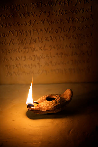 Oil Lamp with Ancient Inscription in Background  old oil lamp stock pictures, royalty-free photos & images