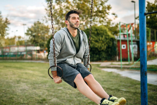 istock Man exercising on gymnastic rings in open air gym 1183139189