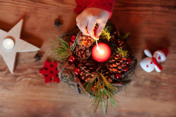 Girl is lighting candles on Advent wreath – High angle view
