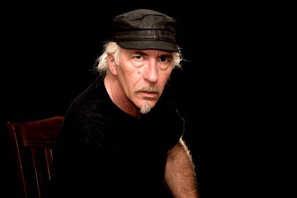 istock man in black leather cap against dark background 1183143177