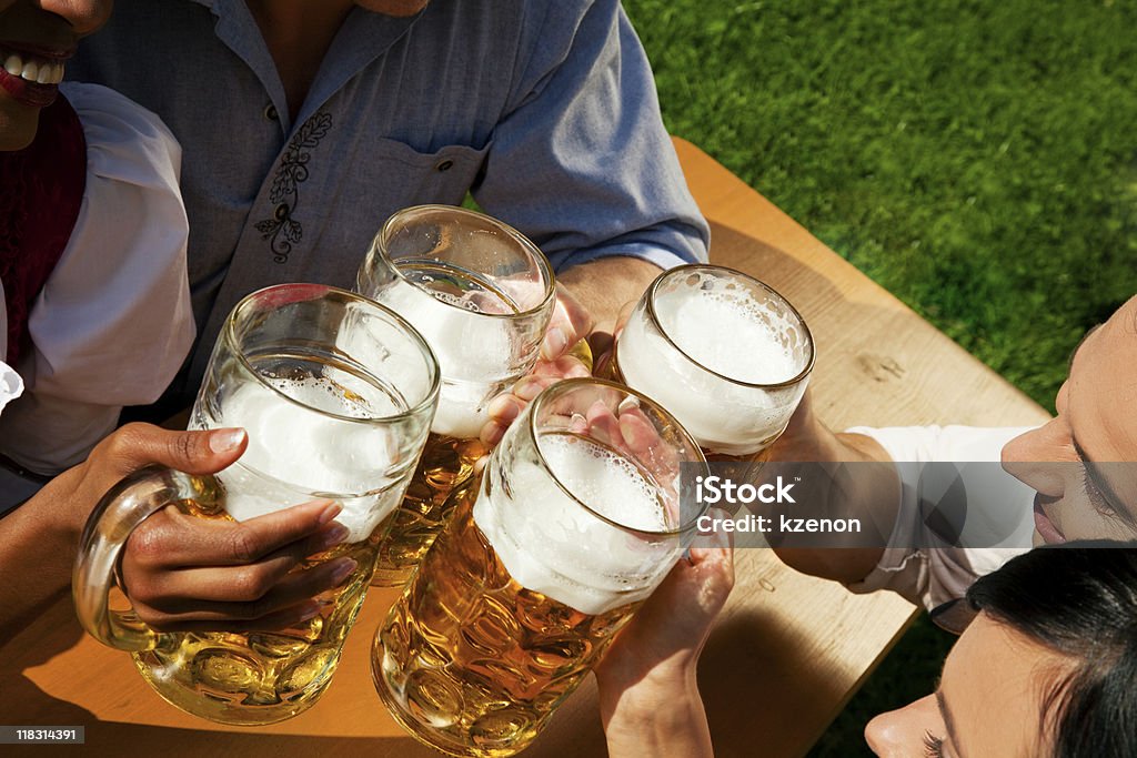 Gruppo di quattro amici, bere birra - Foto stock royalty-free di Adulto