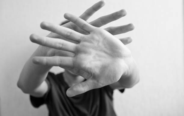 istock 18 years old guy protects himself with his hand 1183151728