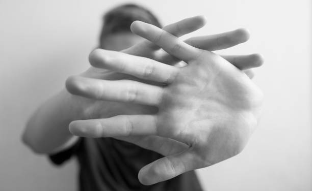 istock 18 years old guy protects himself with his hand 1183151772
