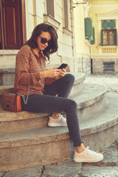 istock Pretty trendy woman using cellphone on the street. 1183151815