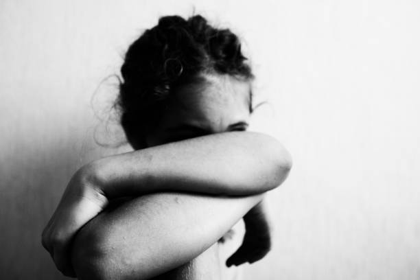 istock Little girl sits and hides her face 1183151893