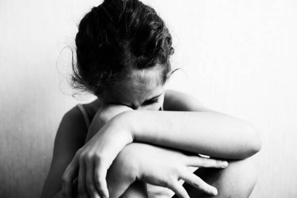 istock Little girl sits and hides her face 1183152032