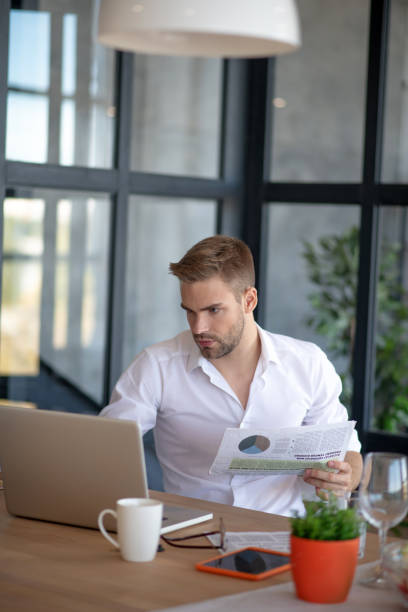istock Businessman reading news and checking e-mail on laptop 1183154002