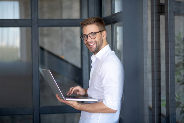 istock Cheerful bearded businessman holding laptop feeling cheerful 1183154016