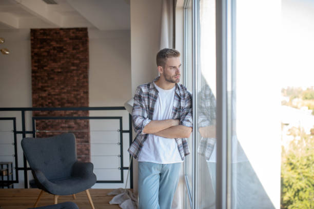 istock Man standing near window and enjoying the view 1183154177