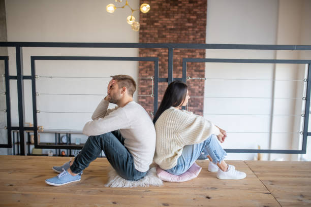 istock Husband and wife sitting back to back after emotional talk 1183156433