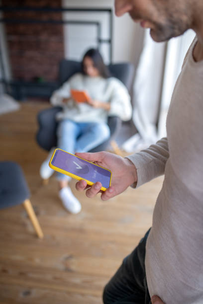 istock Close up of bearded husband holding phone reading message 1183156465