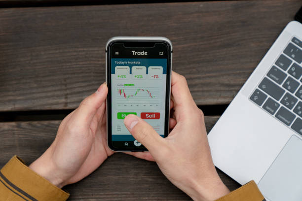 istock Above angle view of a young man using a trading app 1183163169