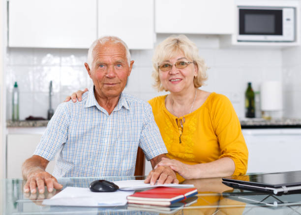 istock Happy mature couple with documents sitting at table in home 1183164721