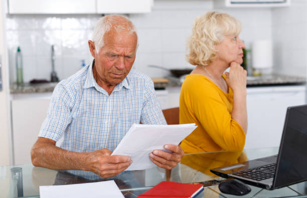 istock Unhappy mature couple with documents having conflict in home 1183164722