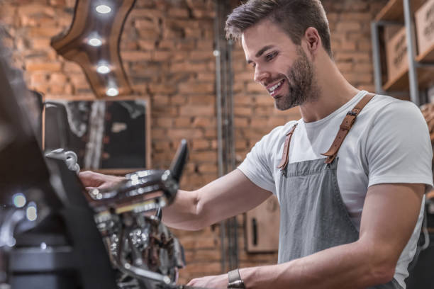 colpo di vista laterale di un barista maschio che fa una tazza di caffè - espresso coffee cafe making foto e immagini stock