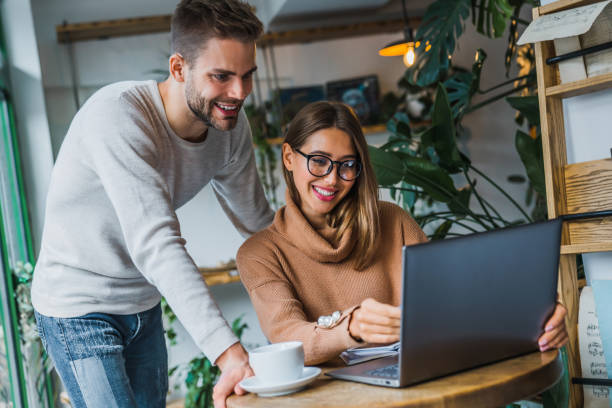 istock Happy friends using laptop at coffee shop 1183169986