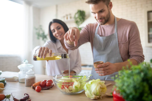 istock Husband and wife seasoning salad while cooking lunch 1183171370