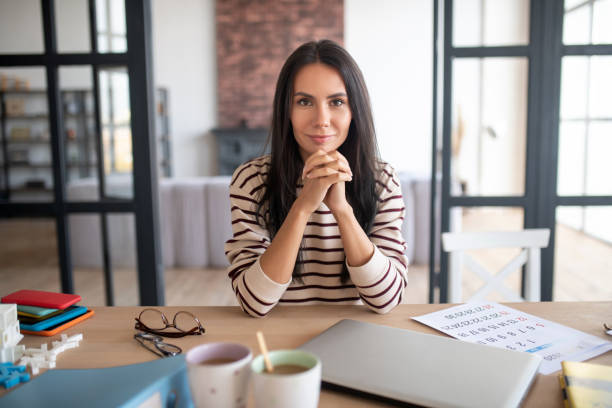 istock Dark-haired woman sitting at the table in spacious room 1183171381