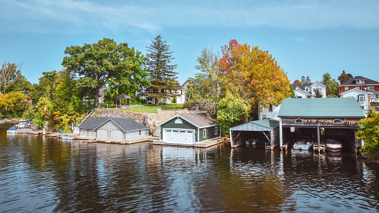 Boat cottage dock. Lake Ontario in autumn. Colorful vivid trees. Canada, United States of America.