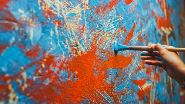 zbliżenie shot of female artist hand, holding paint brush i drawing painting z czerwoną farbą. kolorowe, emocjonalne malarstwo olejne. współczesny malarz tworzący współczesne abstrakcyjne dzieło sztuki pięknej - vibrant color red abstract acrylic painting zdjęcia i obrazy z banku zdjęć
