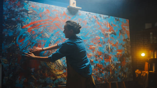 getalenteerde innovatieve vrouwelijke kunstenaar tekent met haar handen op het grote doek, met behulp van vingers creëert ze kleurrijk, emotioneel, sensueel olieverfschilderij. hedendaagse schilder creëren abstracte moderne kunst. - beroep schilder vrouw stockfoto's en -beelden