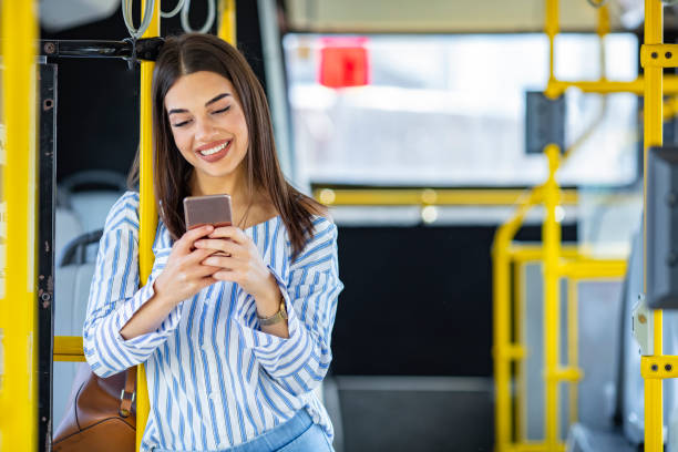 istock Smiling Woman Texting On Phone in Bus 1183188634