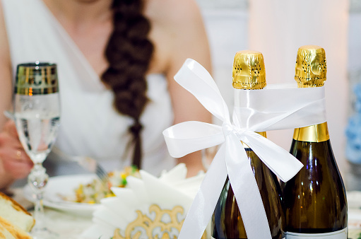 Two bottles of champagne are tied with ribbon. Russian wedding traditions.