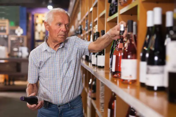 Happy man visiting winehouse in search of bottle of good wine