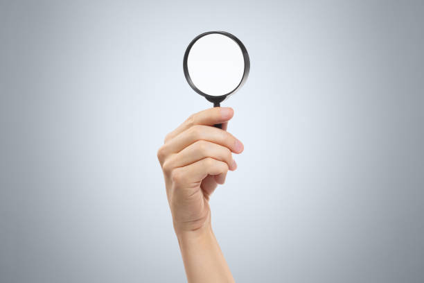istock Hand with a magnifying glass on gray 1183195424