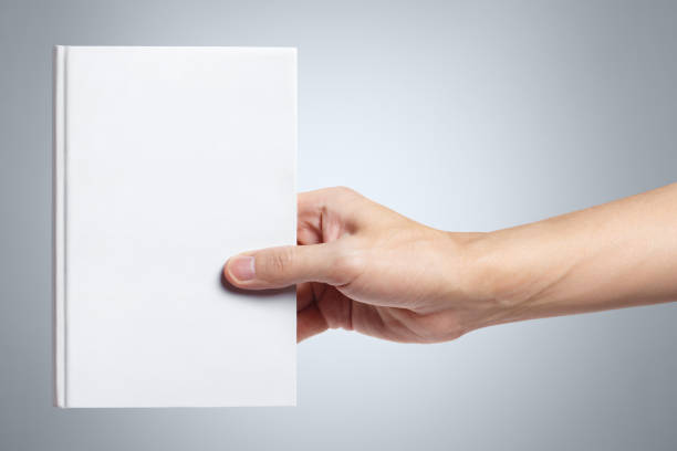 istock Hand holding a book on gray 1183195442