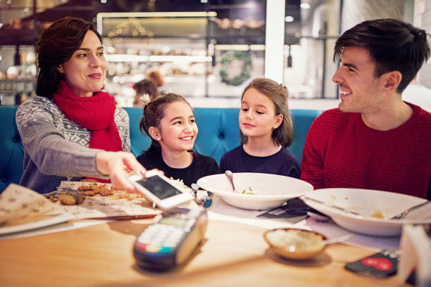 istock Wife is paying using mobile phone in the restaurant at Christmas 1183197400