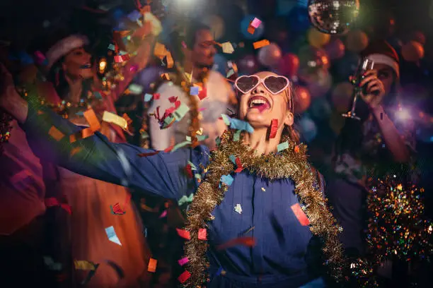 Group of young women and men having fun with balloons at a New Years party