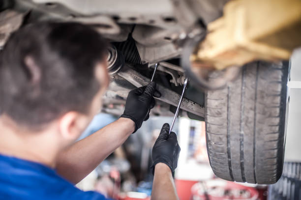 istock Auto mechanic repairer checking condition under car on vehicle lift 1183202272
