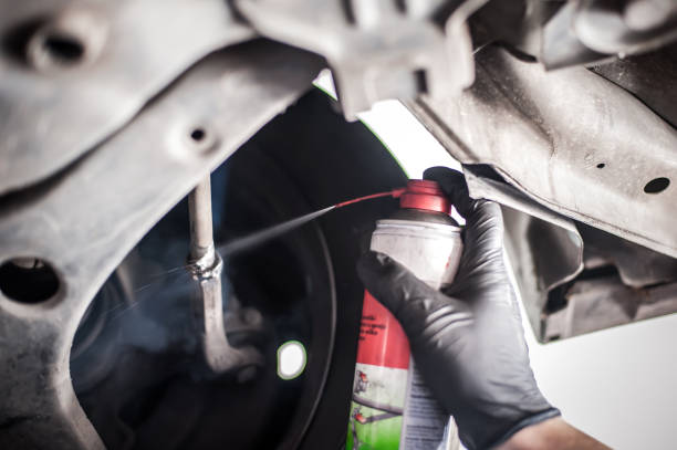 istock Car master mechanic repairer lubricates screws with machine cleaner spray 1183202462