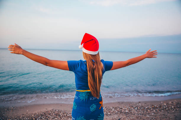 istock Woman with christmas hat on beach 1183202735