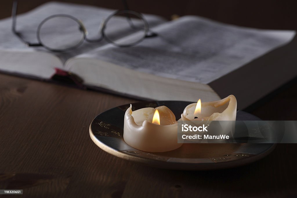 Bruciato a candele e Bibbia lettura di scarsa luminosità - Foto stock royalty-free di Aperto