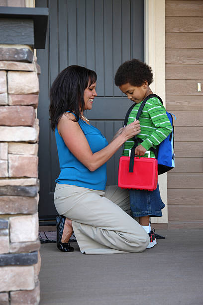 Mother prepares son for his first day of school Mother gets child ready for first day of school lunch box photos stock pictures, royalty-free photos & images