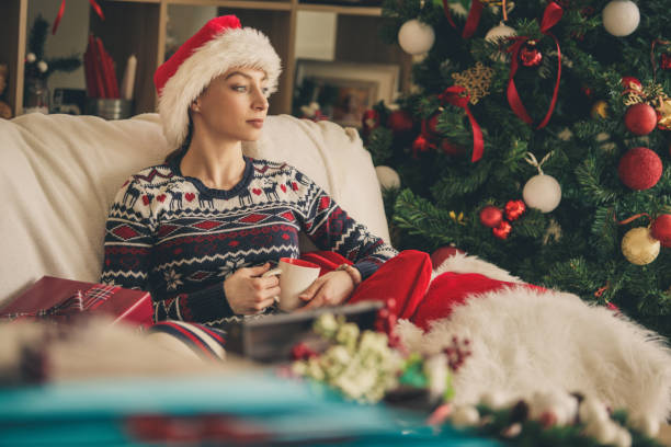 istock Woman relaxing by the Christmas tree 1183219480