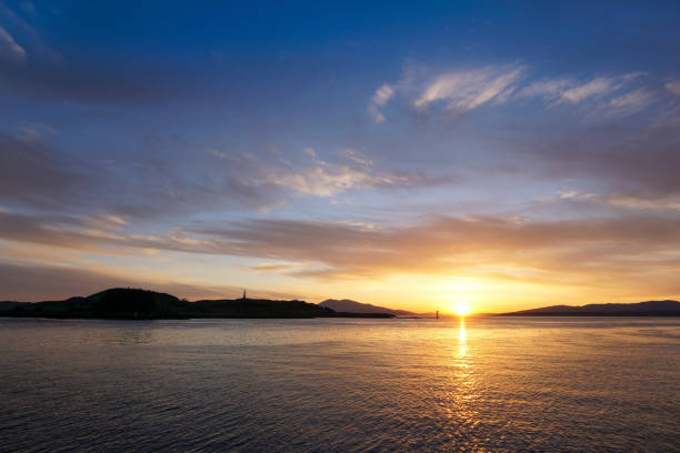 The sun setting at the harbour entrance of Oban bay. In the back is the island Kerrera.