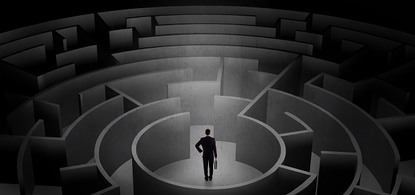 Businessman can not decide which entrance to chose in a middle of a dark maze